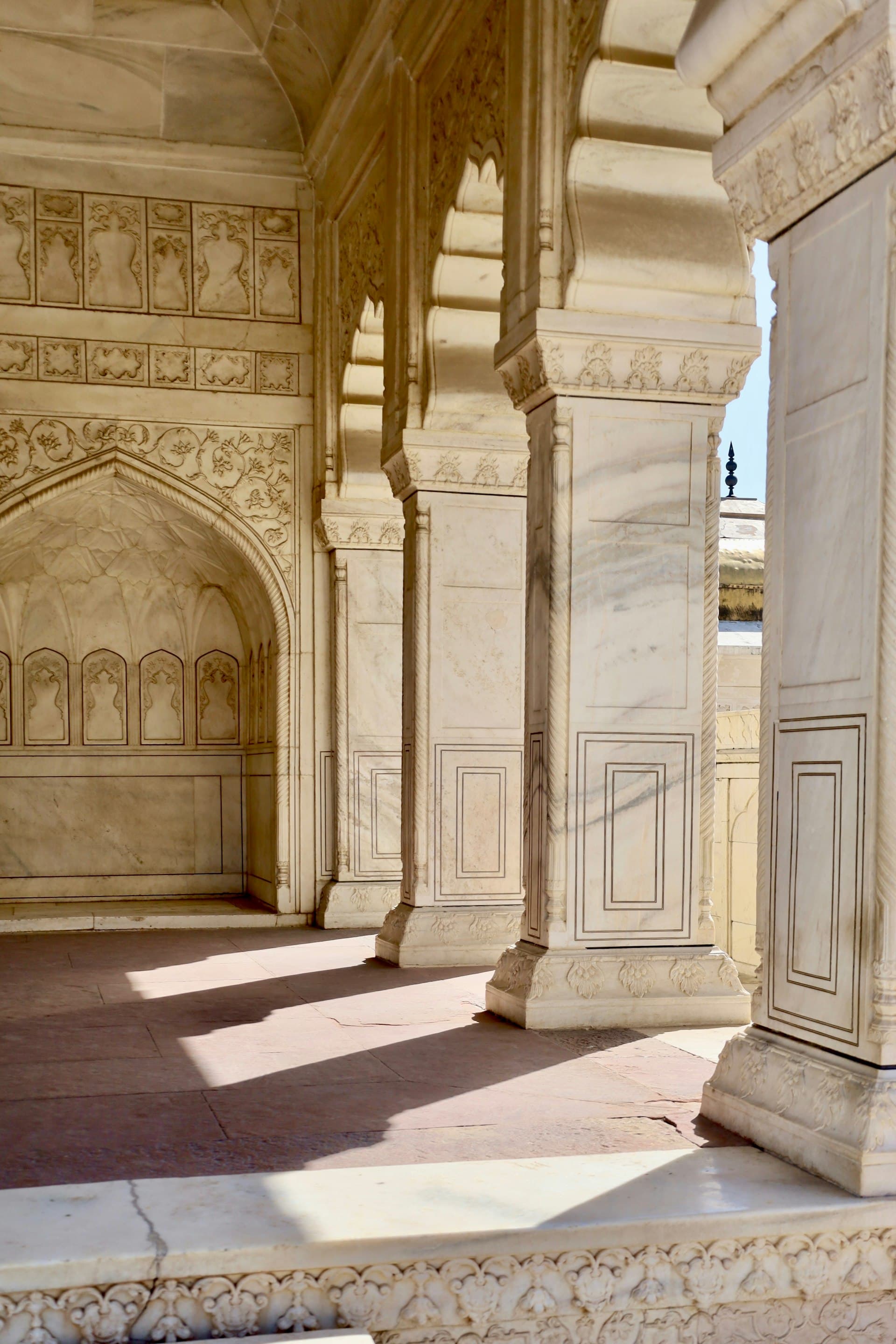 Marble columns with warm sunlight casting shadows